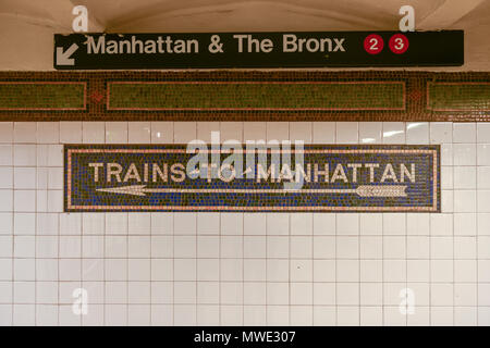 Trains to Manhattan mosaic arrow sign in the  NYC Subway. Stock Photo