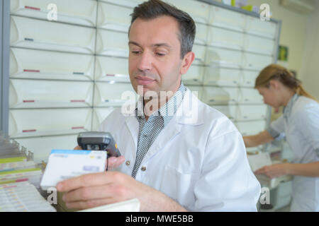 Pharmacist scanning medication Stock Photo
