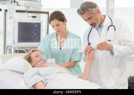 doctors putting an oxygen mask on patient in hospital Stock Photo