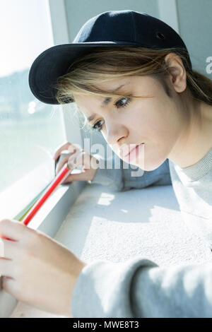 female construction worker putting sealing foam tape on window Stock Photo