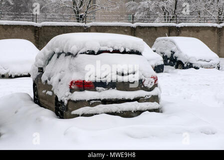 MOSCOW, FEB. 04, 2018: Winter view on cars under snow. Snow covered the cars and they can not move. Dangerous trees under heavy snow. Snow storm on ci Stock Photo