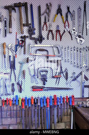 Hand tools organised for easy access on a peg board Stock Photo
