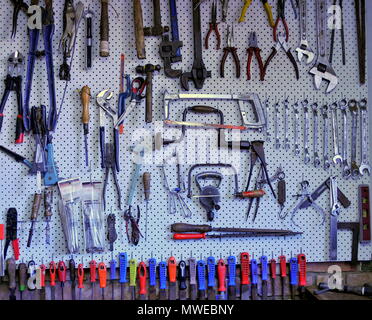 Hand tools organised for easy access on a peg board Stock Photo