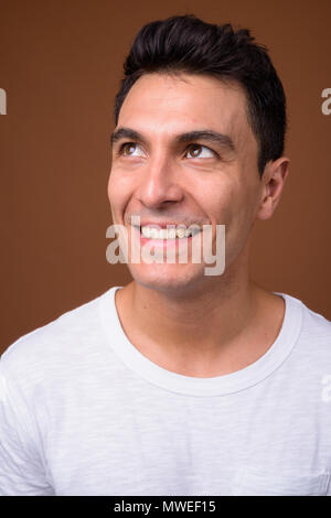 Young handsome Hispanic man against brown background Stock Photo