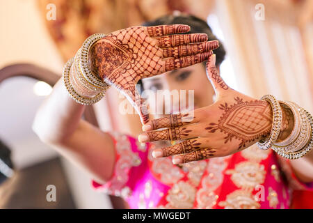 Pakistani & Indian bride wedding making a heart shape her hand