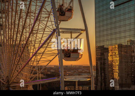 Ferris wheel reflected in the Birmingham Hyatt Hotel at sunset Stock Photo