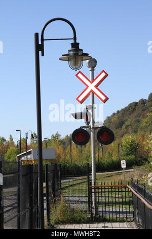 Artificial train crossing signal and lights with exterior decorative light fixture for pedestrians Stock Photo