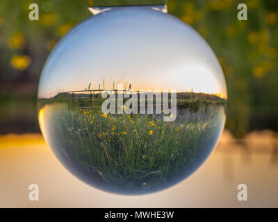 Sunrise on meadow over the river in the glass ball. Podlasie. Poland. Stock Photo