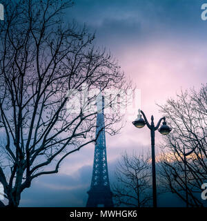 Eiffel Tower at sunset through the trees . Paris. France Stock Photo