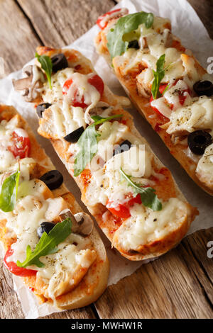 Delicious hot sandwich casserole pizza with chicken, cheese, tomatoes, olives and mushrooms close-up on the table. vertical Stock Photo