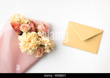 beautiful pink roses in paper wrap with envelope isolated on white Stock Photo