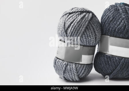 two grey yarn balls with blank tag isolated on white Stock Photo
