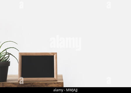 blackboard in frame and plant on table on white Stock Photo