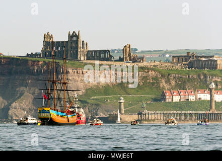 HM Bark Endeavour, a full-scale replica of Captain Cook's ship, sails into Whitby as she is pulled by a tugboat from Middlesbrough to its permanent home in Whitby. Stock Photo