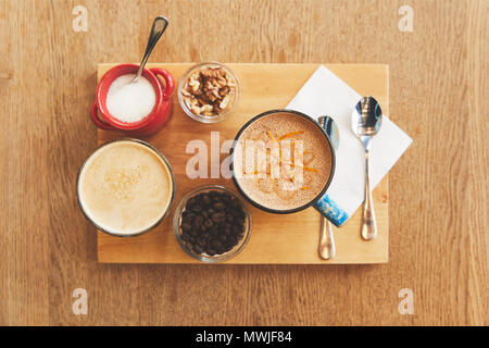 Coffee drinks with walnuts on table in cafe Stock Photo