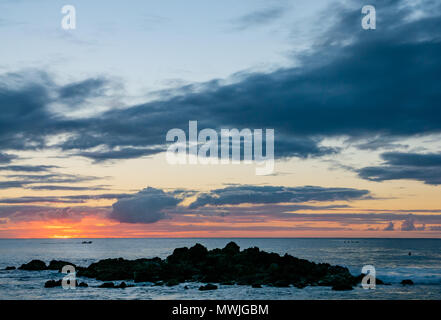 Colourful orange sunset seen from rocky shore of Hanga Roa, Easter Island, Rapa Nui, Chile Stock Photo