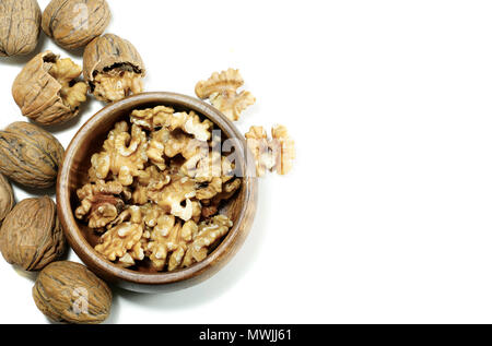 Kernel walnuts in wooden bowl with whole walnuts on isolated white background Stock Photo