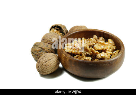 Kernel walnuts in wooden bowl with whole walnuts on isolated white background Stock Photo