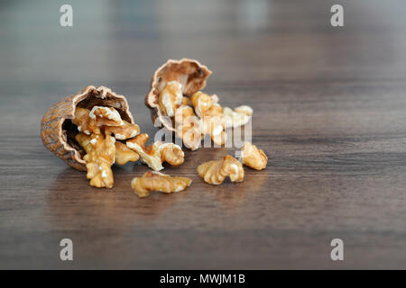 Kernel walnuts in nutshells on dark walnut table background Stock Photo