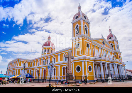 GRANADA, NICARAGUA, MAY, 14, 2018: Outdoor view of Catedral de Granada beautifully decorated in yellow, white and red captured against a blue sky Stock Photo