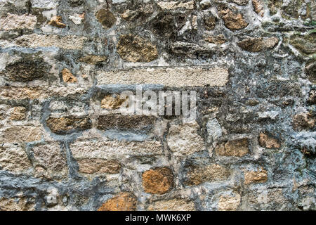Ancient weathered wall constructed of natural cobblestone. Colorful horizontal image suitable for interior design, backdrop, wallpaper. Stock Photo