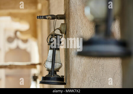 Old antique oil lantern hanging on wall Stock Photo