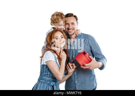 Cheerful man with adorable little son presenting gift box to young woman and smiling at camera Stock Photo