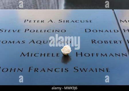 Names of 9/11 victims on pool parapet with white rose, National September 11 Memorial & Museum, New York, USA Stock Photo