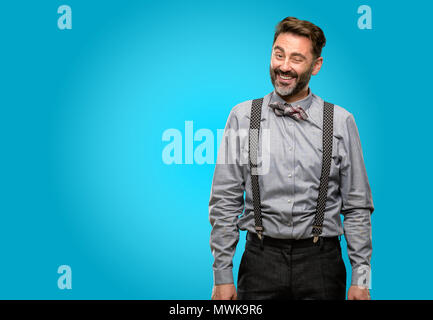 Middle age man, with beard and bow tie blinking eyes with happy gesture Stock Photo