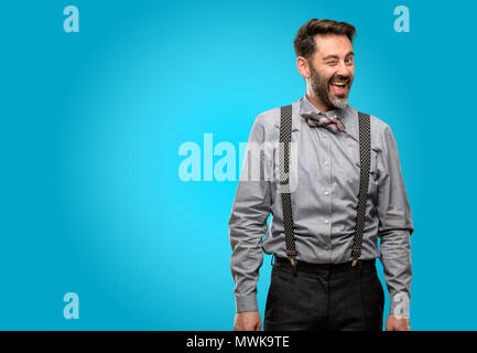 Middle age man, with beard and bow tie blinking eyes with happy gesture Stock Photo