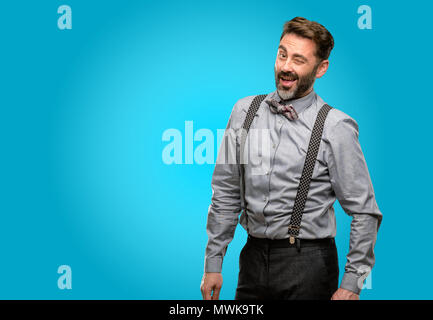 Middle age man, with beard and bow tie blinking eyes with happy gesture Stock Photo