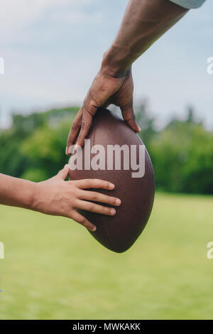 https://l450v.alamy.com/450v/mwkakk/partial-view-of-father-and-daughter-holding-rugby-ball-together-mwkakk.jpg