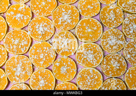 Beautiful texture of sliced orange with oat flakes on pink background Stock Photo