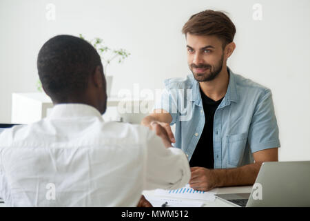 Friendly Caucasian worker greeting black job candidate with hand Stock Photo