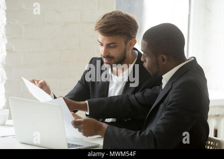Serious businessmen discussing company paperwork in office Stock Photo