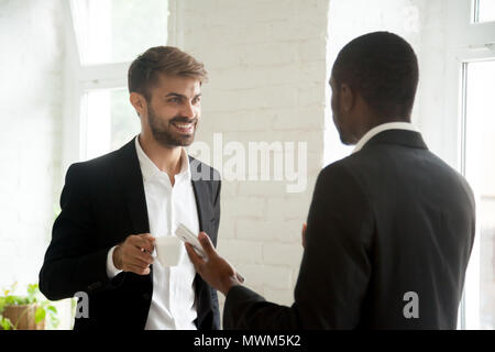 Multiethnic colleagues having business conversation during coffe Stock Photo