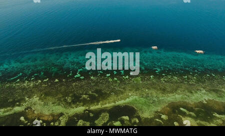 Aerial image of motorboat floating in a turquoise blue sea water. The ...
