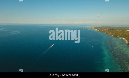 Aerial image of motorboat floating in a turquoise blue sea water. The ...