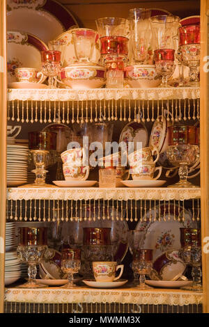 Glassware and fine china inside an Antique buffet in the living room of an old Canadiana log home Stock Photo