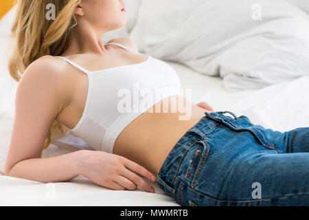 cropped view of girl in jeans undressing isolated on grey Stock Photo -  Alamy