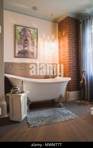 White porcelain claw foot bathtub in the main bathroom inside an old 1877 cottage style residential home Stock Photo