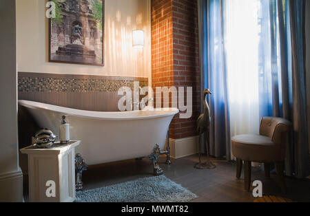 White porcelain claw foot bathtub in the main bathroom inside an old 1877 cottage style residential home Stock Photo