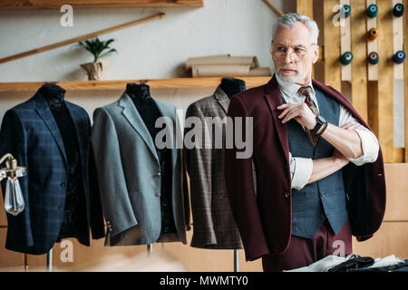 serious mature tailor in stylish clothes at sewing workshop Stock Photo