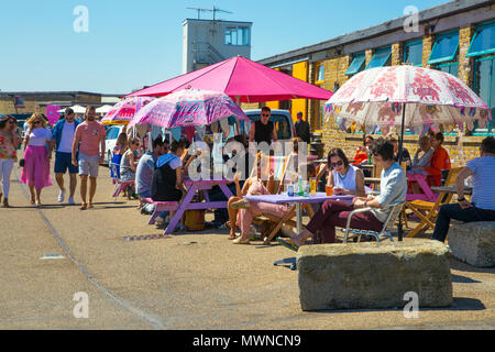 People sitting at cafe (BeBeached Cafe) tables on a hot summer day at the Harbour Arm in Margate, UK Stock Photo