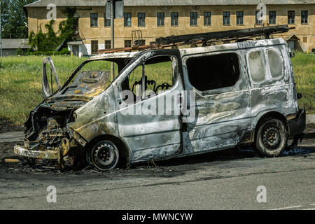 Fully burned minivan on the city road Stock Photo