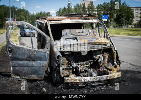 Fully burned minivan on the city road Stock Photo