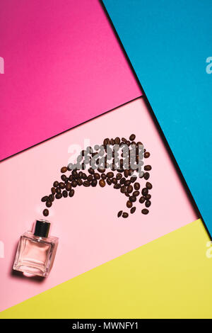 top view of bottle of perfume with coffee beans on colorful surface Stock Photo