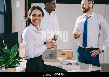 smiling multiethnic colleagues having coffee break in new office during relocation Stock Photo
