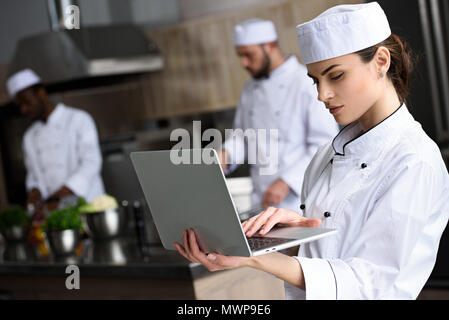 beautiful chef using laptop at restaurant kitchen Stock Photo