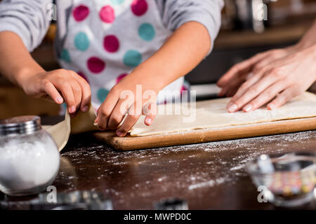 cropped shot of family putting raw dough on cutting board while cooking together Stock Photo